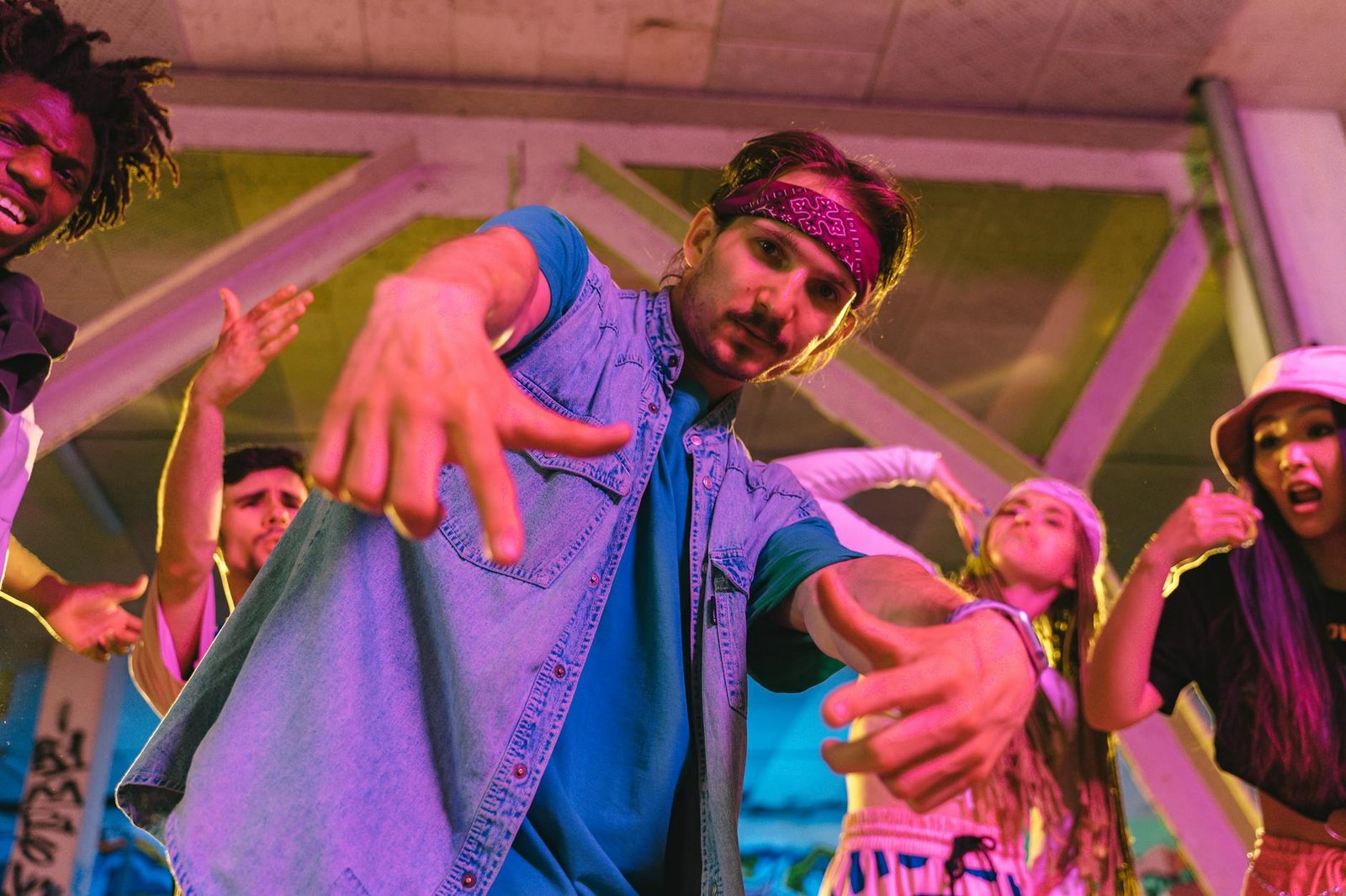 A diverse group of young adults energetically dancing under neon lights, expressing vibrant hip hop culture.