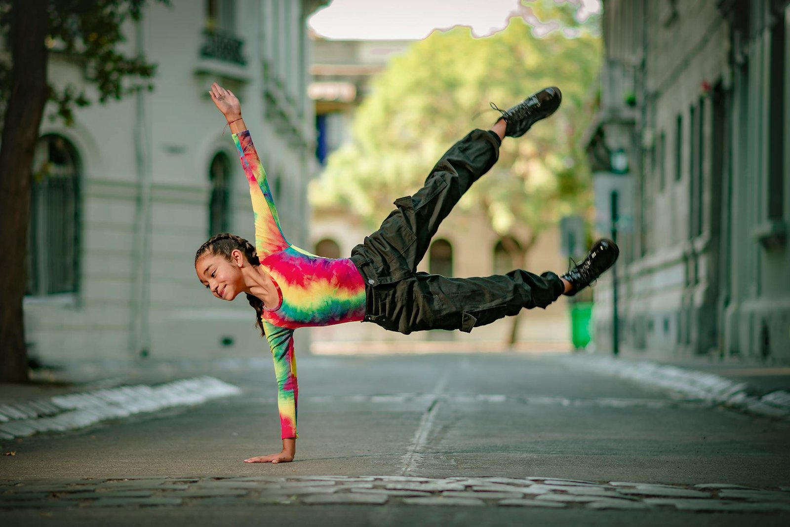 Talented dancer performs an acrobatic move on an empty urban street.