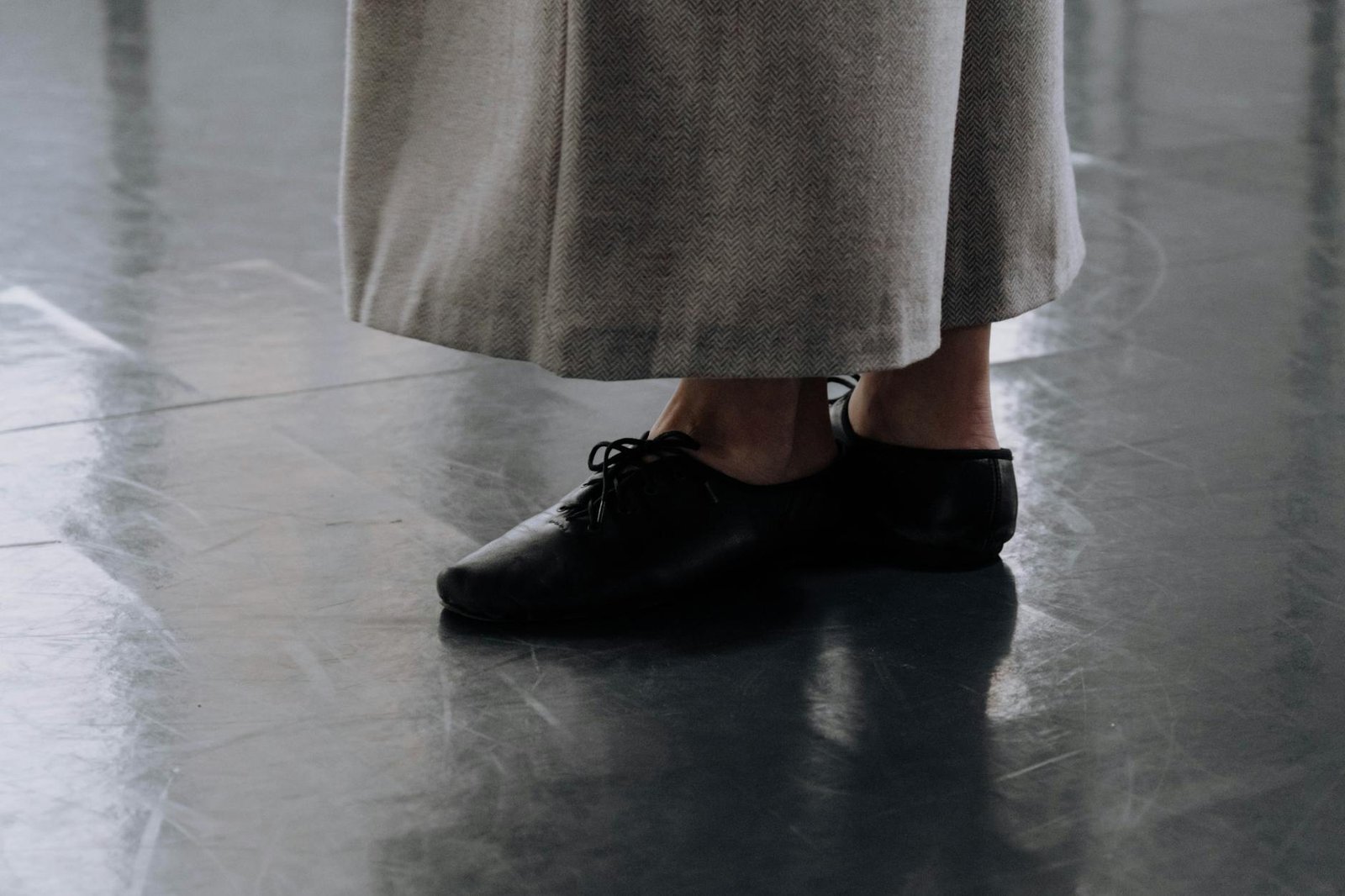 Artistic close-up of dance shoes on a studio floor, emphasizing movement.