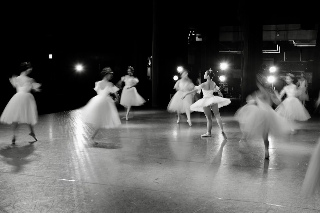 Ballerinas dancing on a stage with spotlights