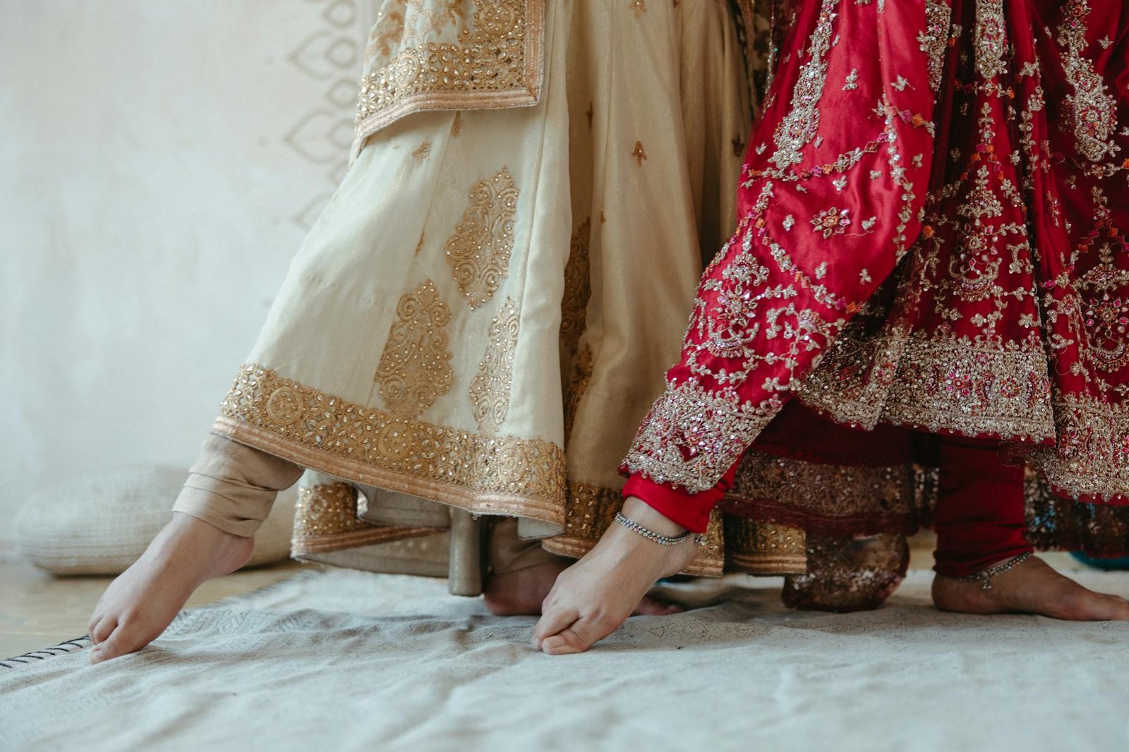 Close-up of feet in ornate traditional Indian dresses during a sacred dance indoors.