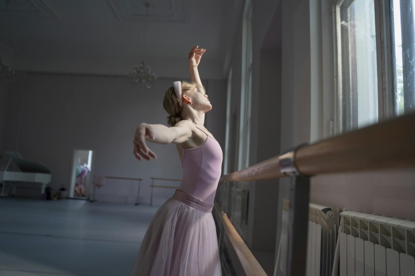 Elegant ballerina practicing gracefully in a light-filled dance studio, embodying poise and passion.