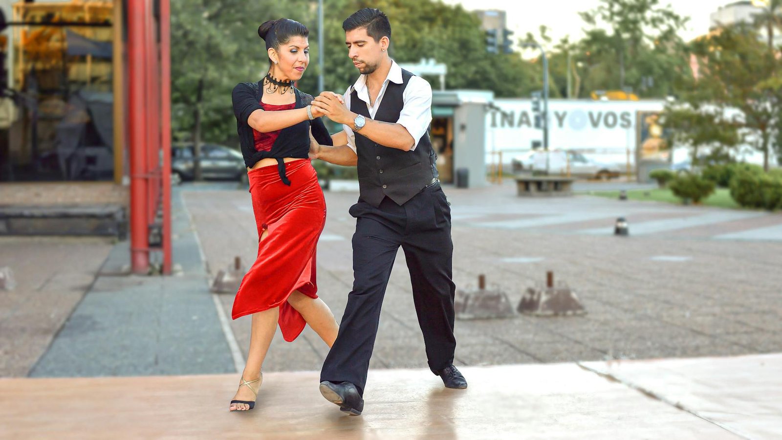 A couple gracefully performing tango on the streets of Buenos Aires, capturing the essence of dance and culture.