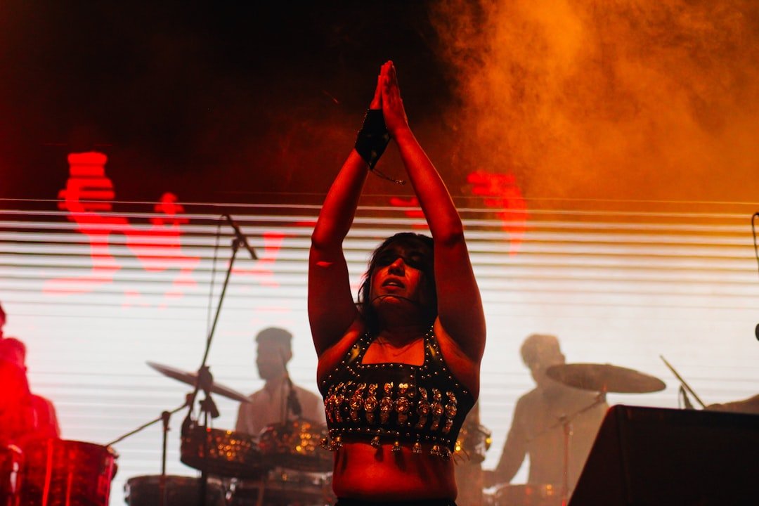 A woman standing on a stage with her arms in the air