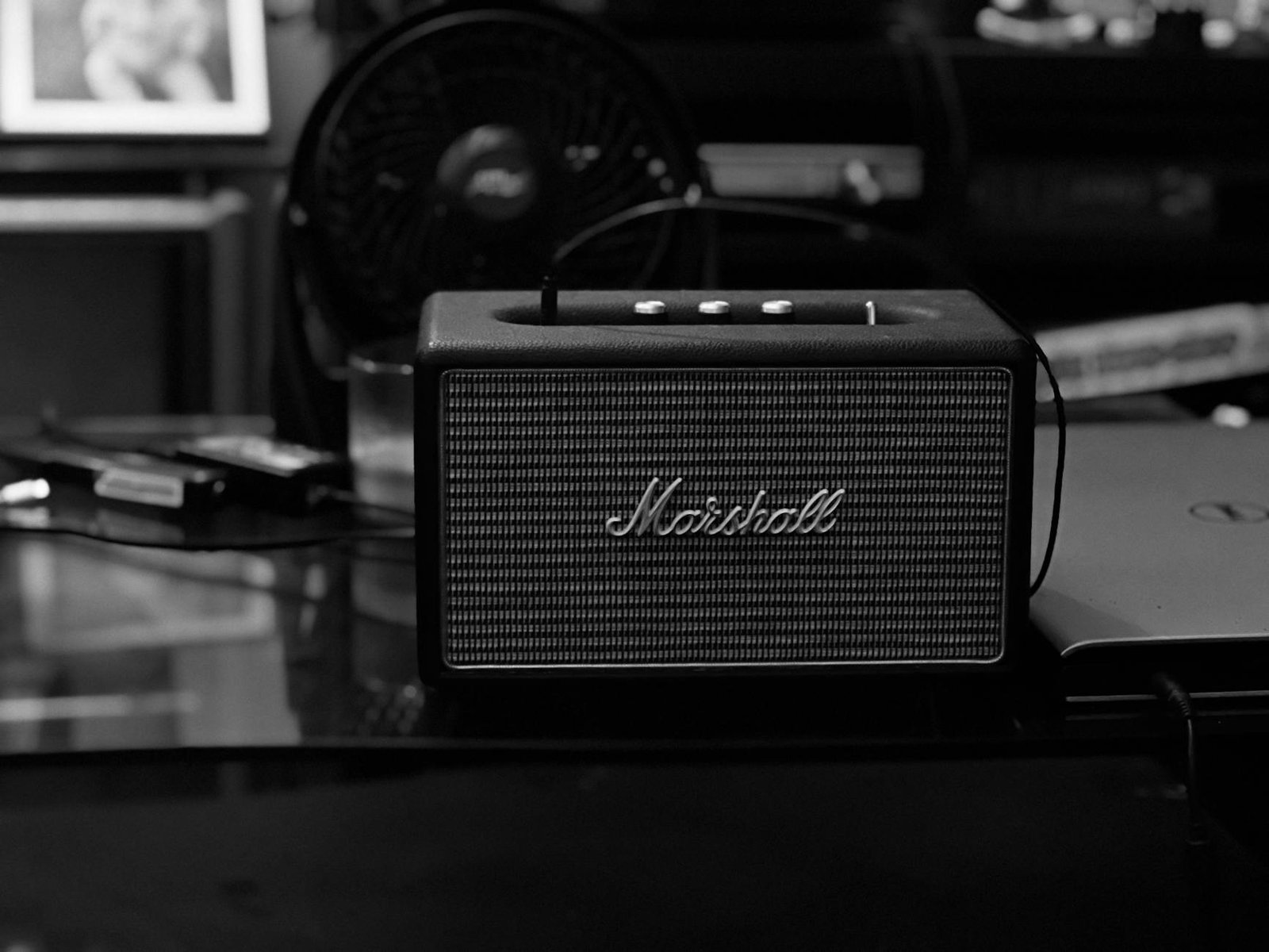 Black and white photograph of a Marshall Bluetooth speaker on a table.