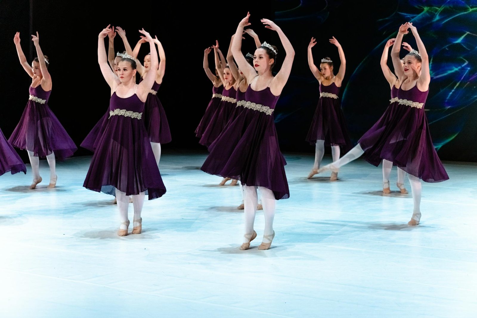 A graceful ballet performance with dancers in purple dresses on stage.