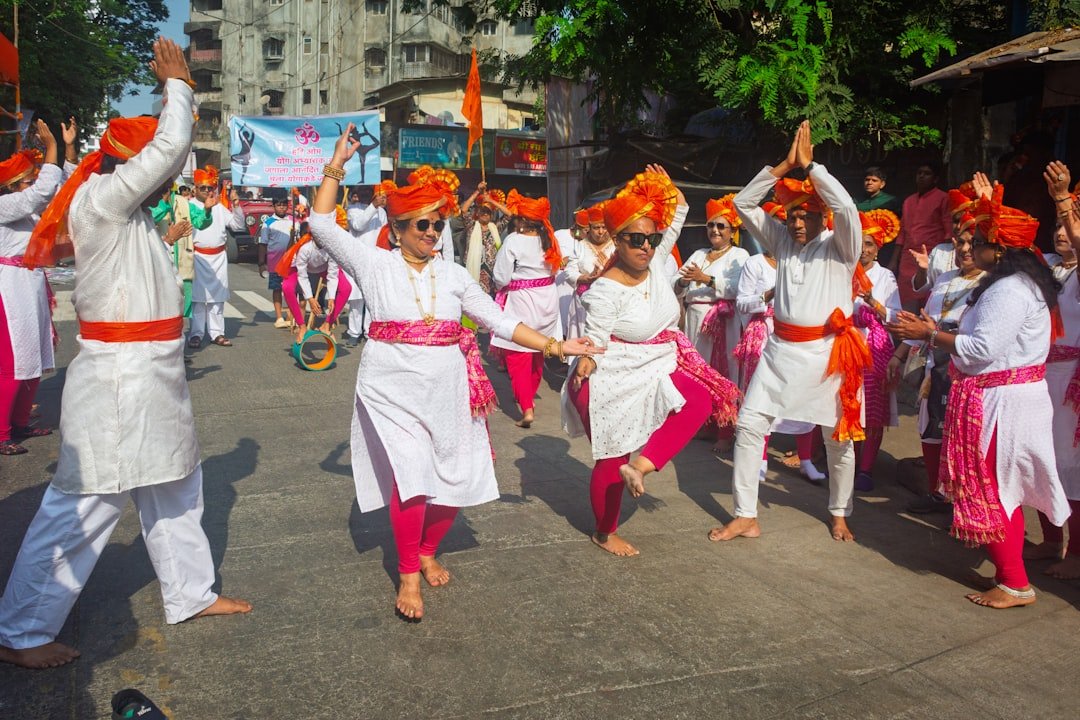 People in traditional indian attire dancing in a street celebration.