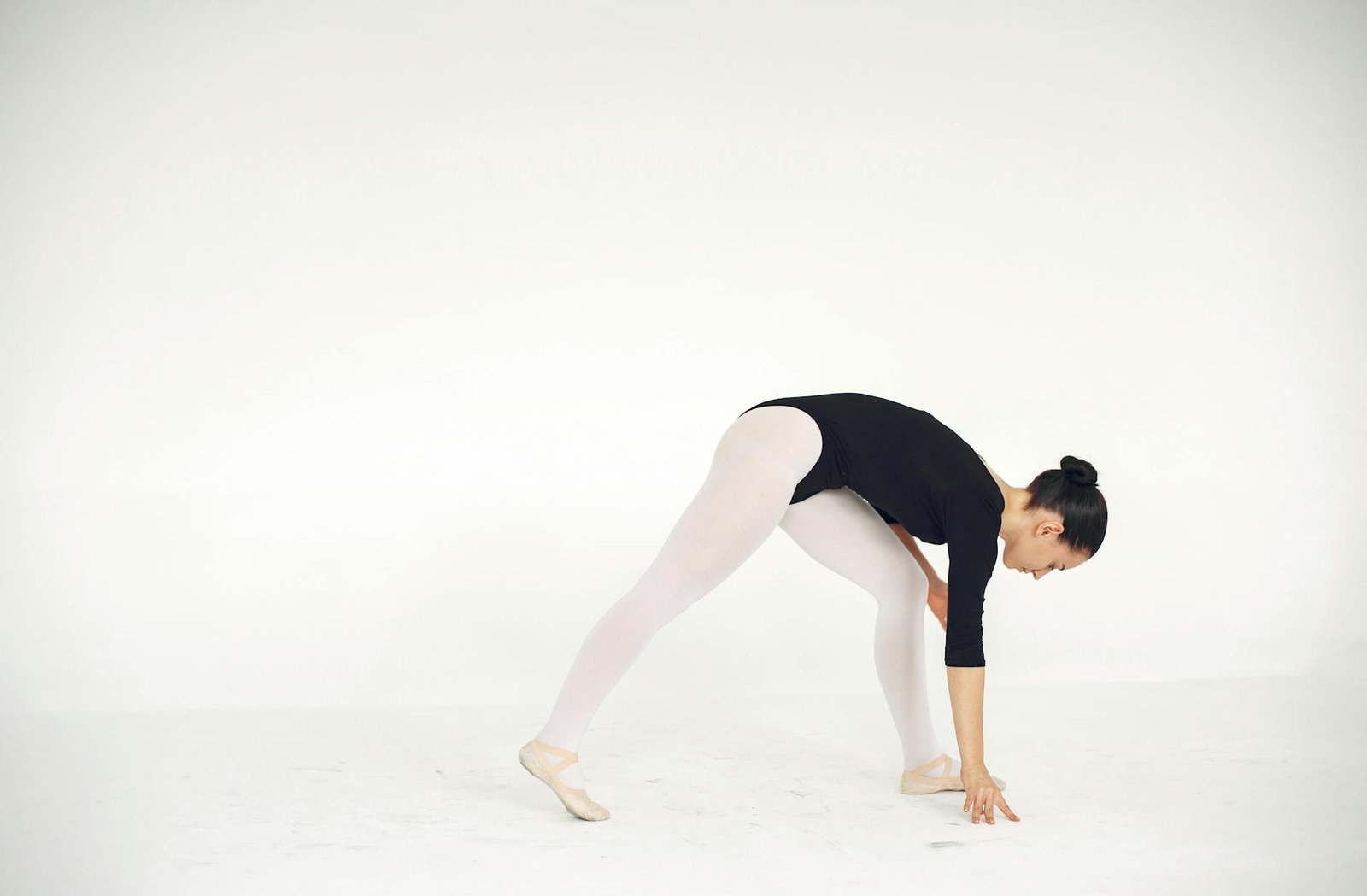 Elegant image of a ballerina stretching in a studio, showcasing flexibility and grace.