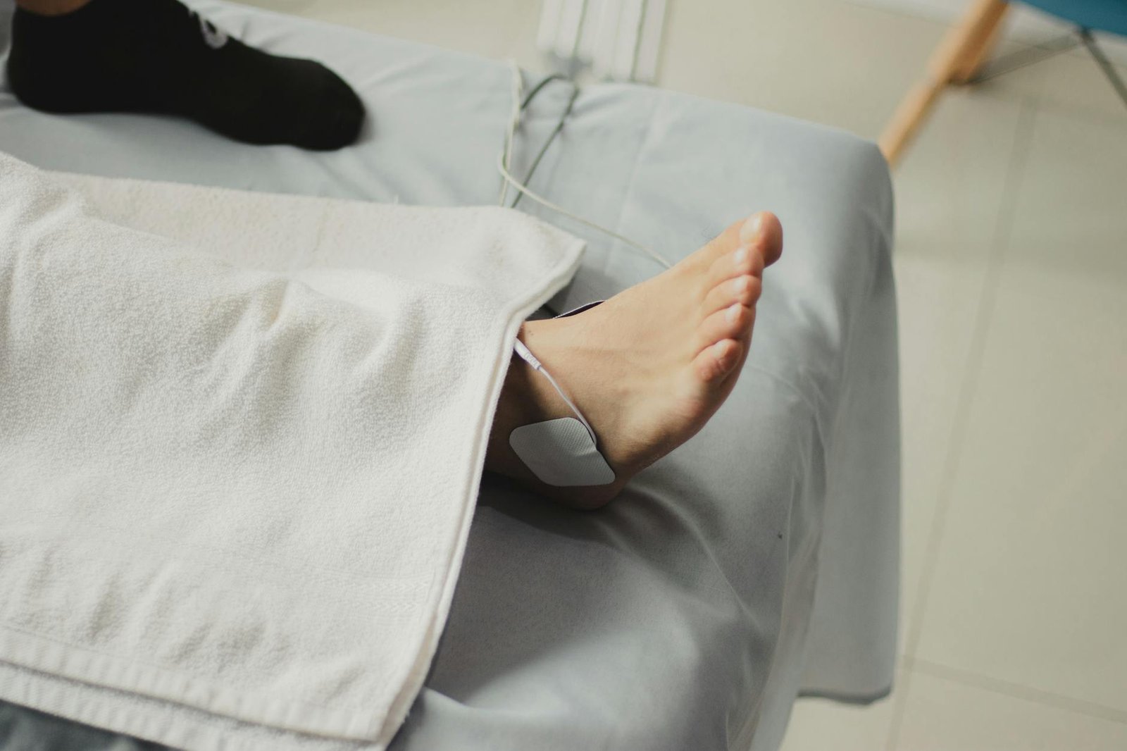 A close-up image of a bare foot with a medical electrode, suggesting a healthcare setting.