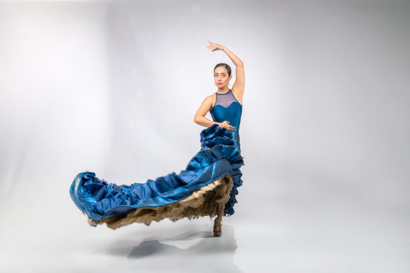 Graceful flamenco dancer in blue dress captured mid-performance in Mexico City.
