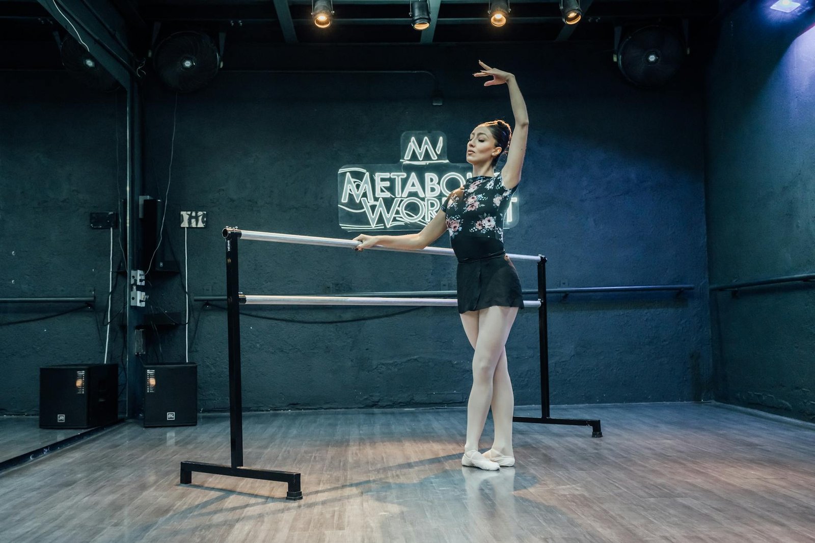 Elegant ballet dancer posing gracefully in a dance studio with a modern backdrop.