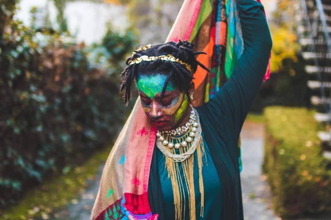 A woman is adorned with colors and scarves.
