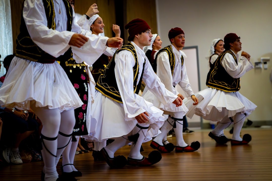 Dancers in traditional greek costumes perform a folk dance.
