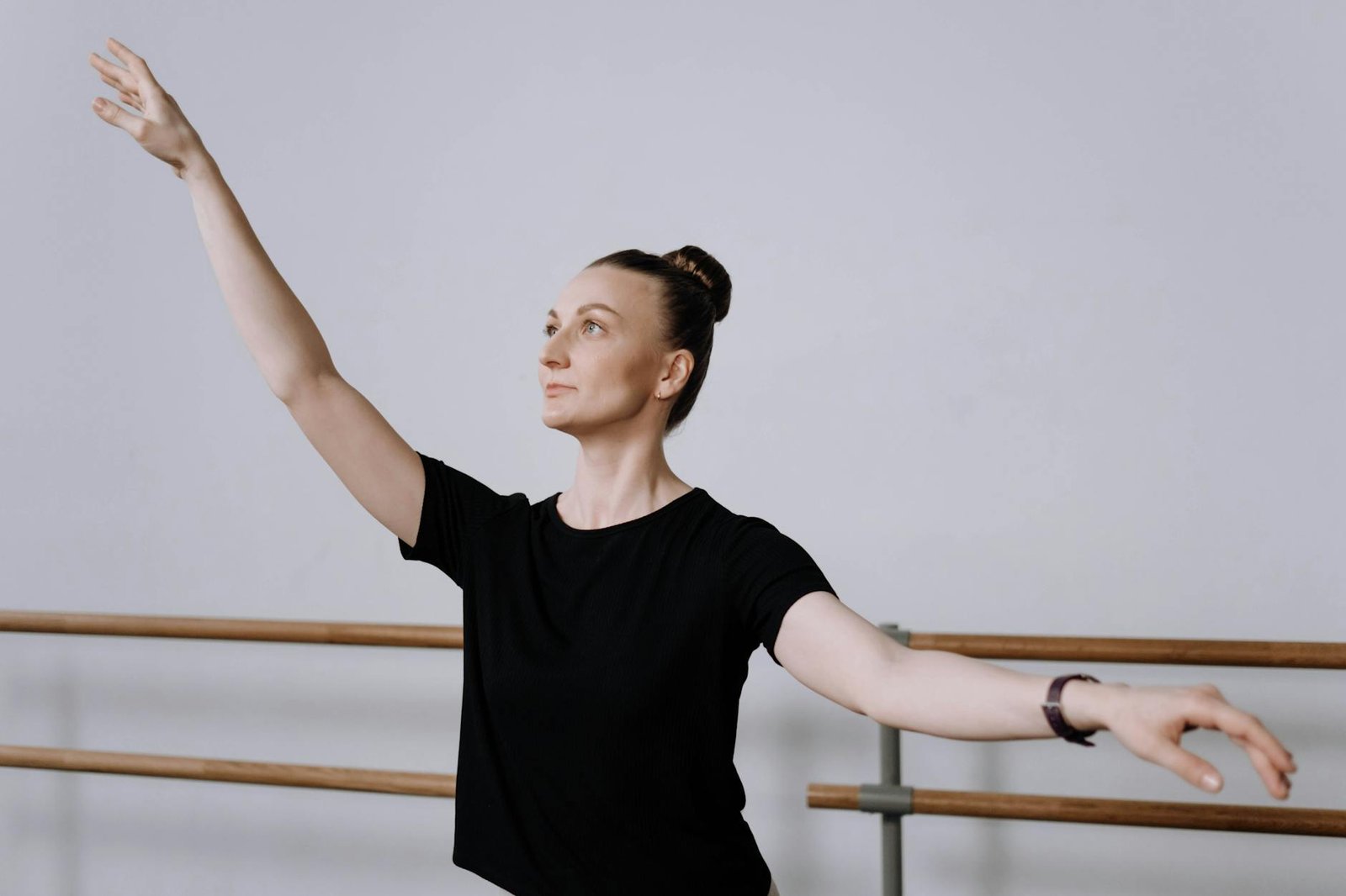 A woman practicing ballet in a studio, capturing elegance and focus in a dance pose.