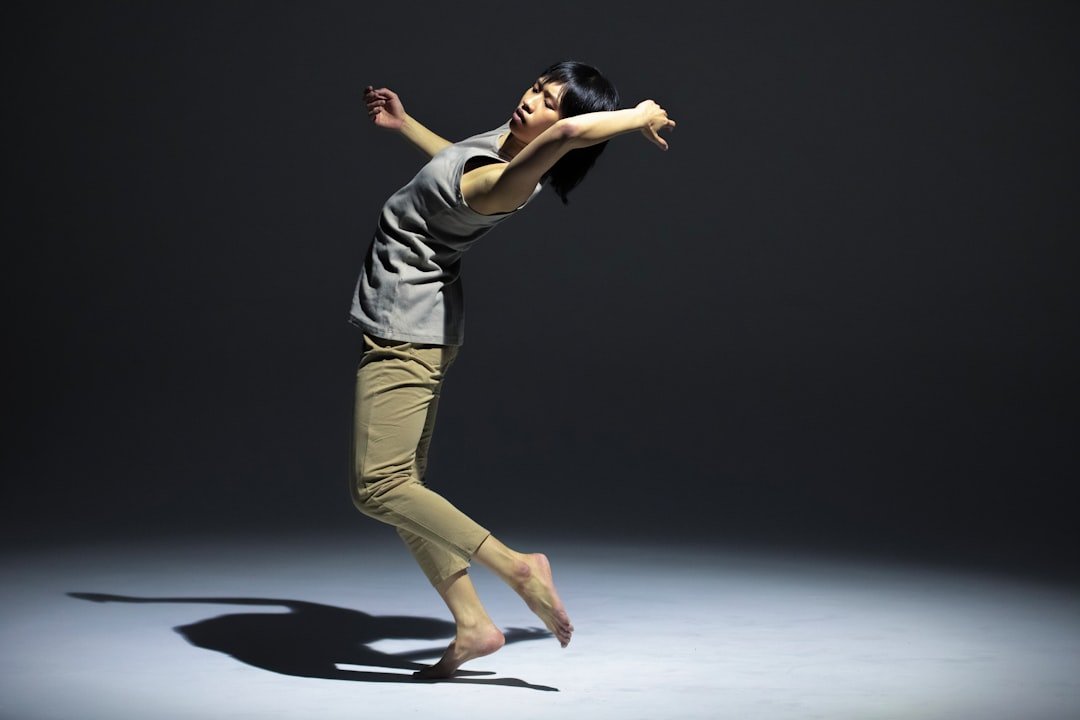 a woman is jumping in the air with her arms outstretched