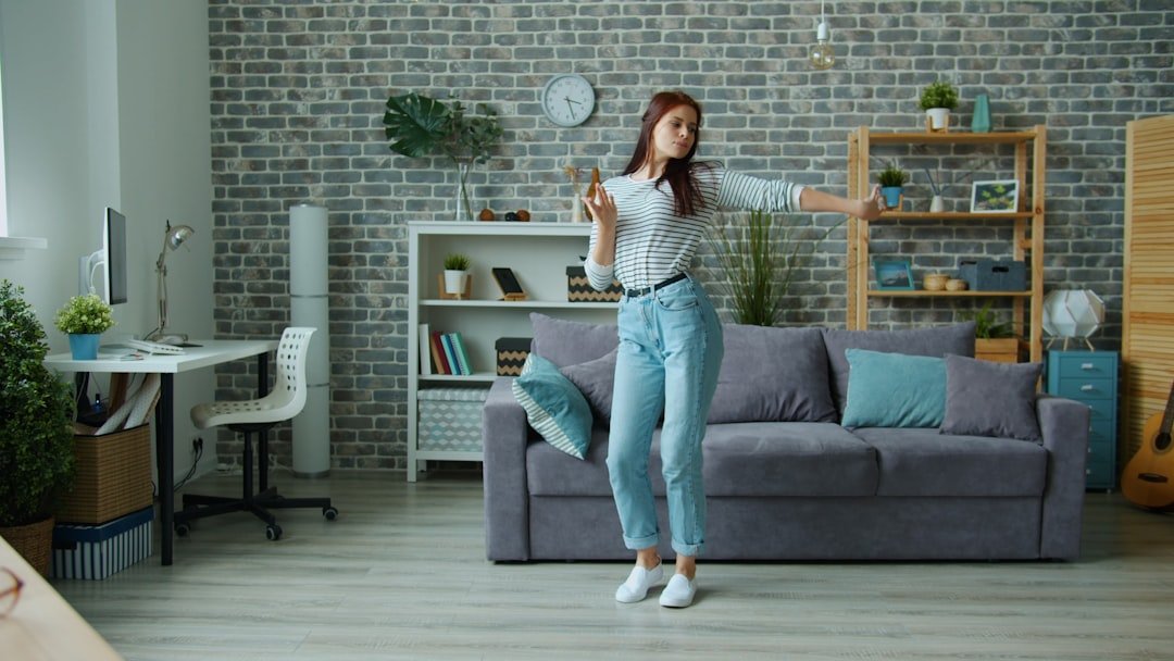 Young woman dancing happily in a modern living room.