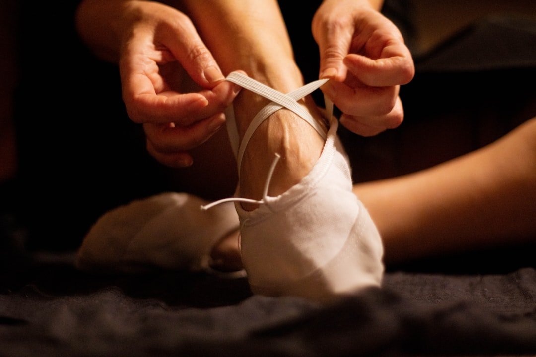 Dancer tying ballet shoes before performance