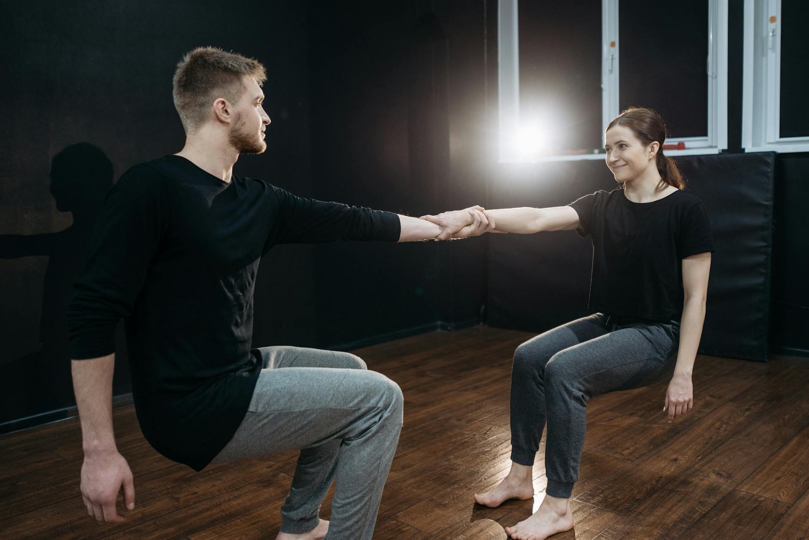 A male and female dancer perform a contemporary dance routine in a dance studio, showcasing balance and synergy.